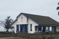 This image made from video provided by Broadcom Broadcasting shows a damaged Mormon church on the Tongan island of Atata, Sunday, Jan. 16, 2022, the day after tsunami caused by a volcanic eruption near Tonga. (Kilo Folau/Broadcom Broadcasting via AP)