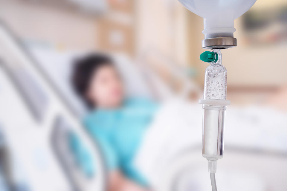 Medical drip with patient in the hospital blurred background