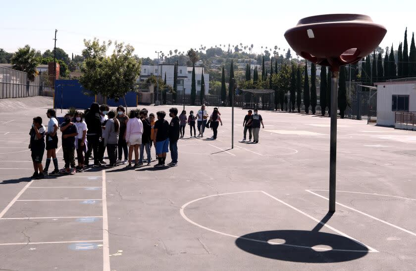 LOS ANGELES, CA - AUGUST 31, 2022 - - With very little shade in sight students prepare to return to class after a midmorning recess at Lockwood Elementary School on August 31, 2022. With temperatures rising in Los Angeles the principal of the school decided that students would not be allowed to play in the yard in the afternoon due to extreme hot weather. Lockwood Elementary School is the number one school in LAUSD's greening index meaning it is the most in need of green space out of all schools. (Genaro Molina / Los Angeles Times) ATTENTION PRE-PRESS: PLEASE DO NOT LIGHTEN FACES AS TO NOT IDENTIFY STUDENTS.