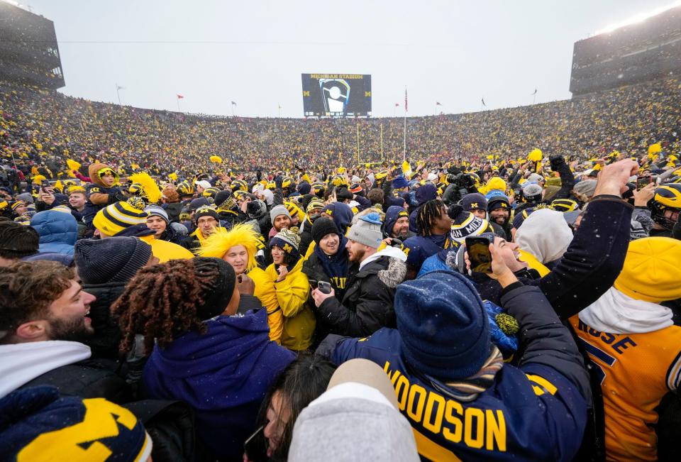 Wolverines fans rush the field to celebrate the 42-27 win over the Buckeyes.