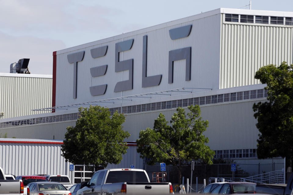 FILE -This June 22, 2012, file photo, shows an exterior view of the Tesla factory in Fremont, Calif. The parking lot was full at Tesla's California electric car factory Monday, May 11, 2020, an indication that the company was resuming production in defiance of an order from county health authorities. (AP Photo/Paul Sakuma, File)