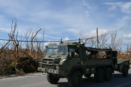 Military personnel drive past damage in the wake of Hurricane Dorian in Marsh Harbour