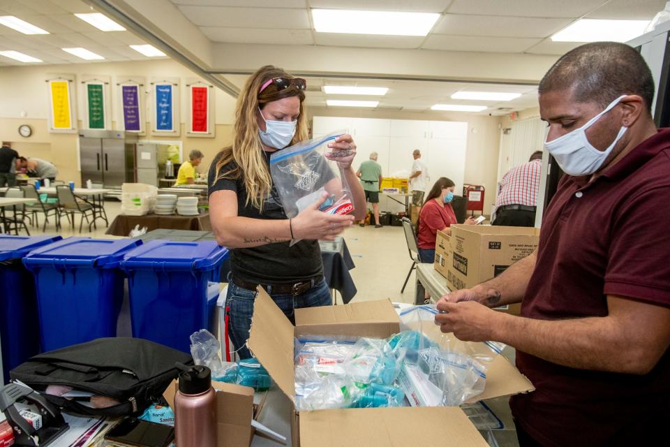 Martha's Village and Kitchen employees Kelsey Manning, left, and Gabriel Romero prepare hygiene bags for clients of the new 24-hour cooling center located at the United Methodist Church in Palm Springs, Calif., on July 6, 2021. 