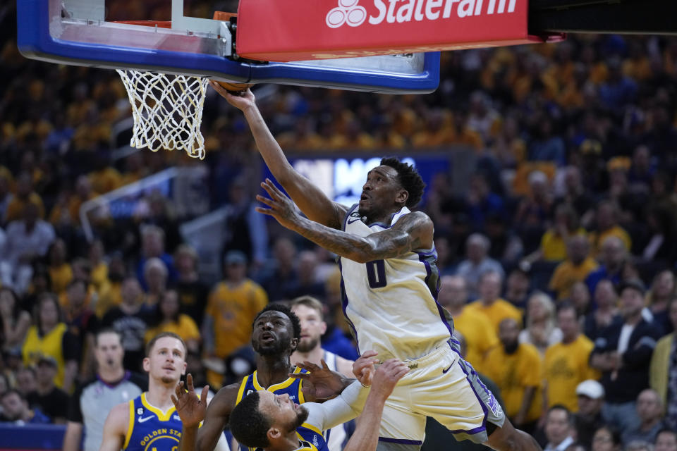 Sacramento Kings guard Malik Monk, top center, tries to shoot over Golden State Warriors guard Stephen Curry, bottom center, during the first half of Game 6 of a first-round NBA basketball playoff series in San Francisco, Friday, April 28, 2023. (AP Photo/Godofredo A. Vásquez)