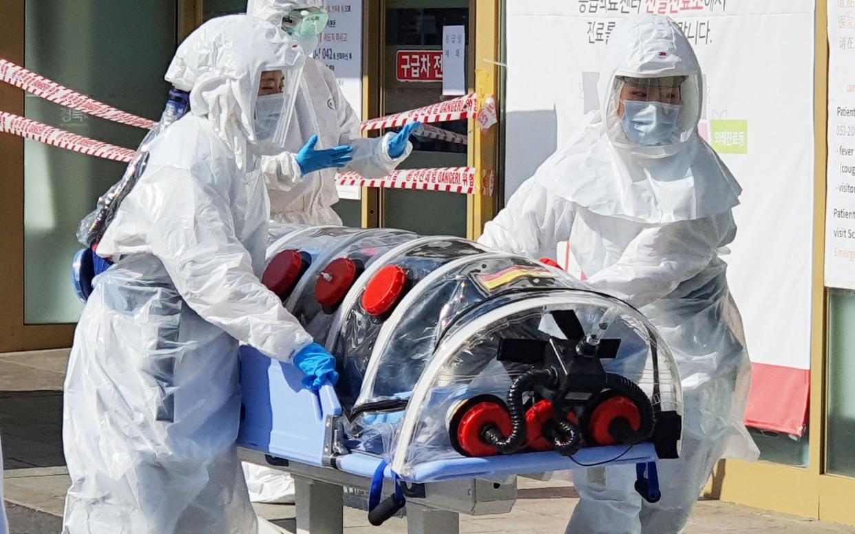 A patient suspected of carrying coronavirus, arrives at Kyungpook National University Hospital in Daegu, South Korea - YONHAP/EPA-EFE/REX