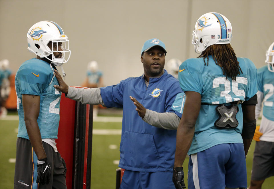 FILE - Assistant defensive backs coach Daronte Jones, center, talks with safety Isa Abdul-Quddus, left, and free safety Walt Aikens (35), during an NFL football practice in Davie, Fla., in this Wednesday, Aug. 17, 2016, file photo. Daronte Jones is the new defensive coordinator for the LSU NCAA college football team. Jones had an introductory media conference on Tuesday, Feb. 2, 2021. (AP Photo/Lynne Sladky, FIle)