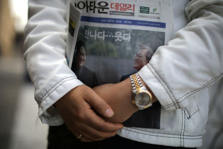 Ssoonie Kim, 45, holds a newspaper with a front page story about the inter-Korean summit between North Korea’s Kim Jong Un and South Korean President Moon Jae-in, in Koreatown, Los Angeles, California, April 27, 2018. REUTERS/Lucy Nicholson
