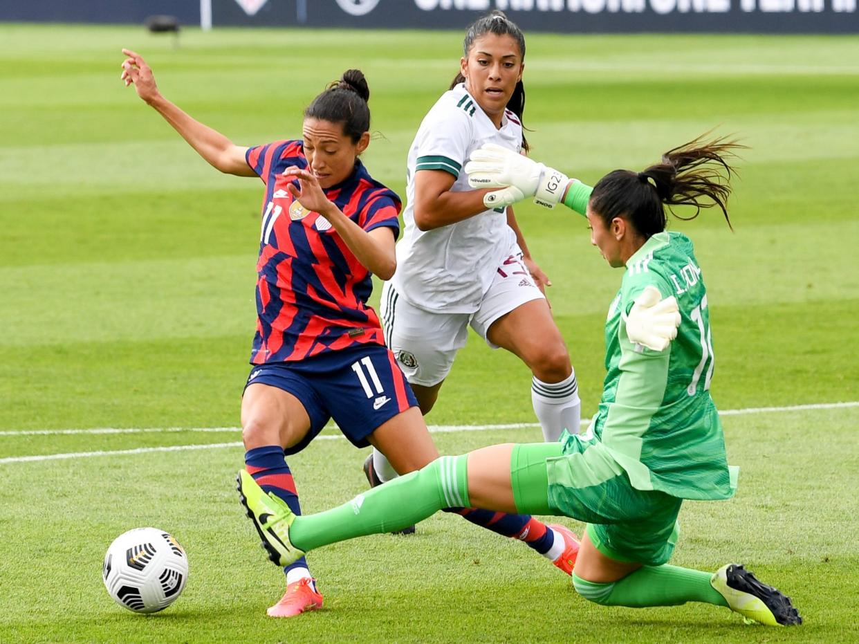 Christen Press dribbles around the goalie.