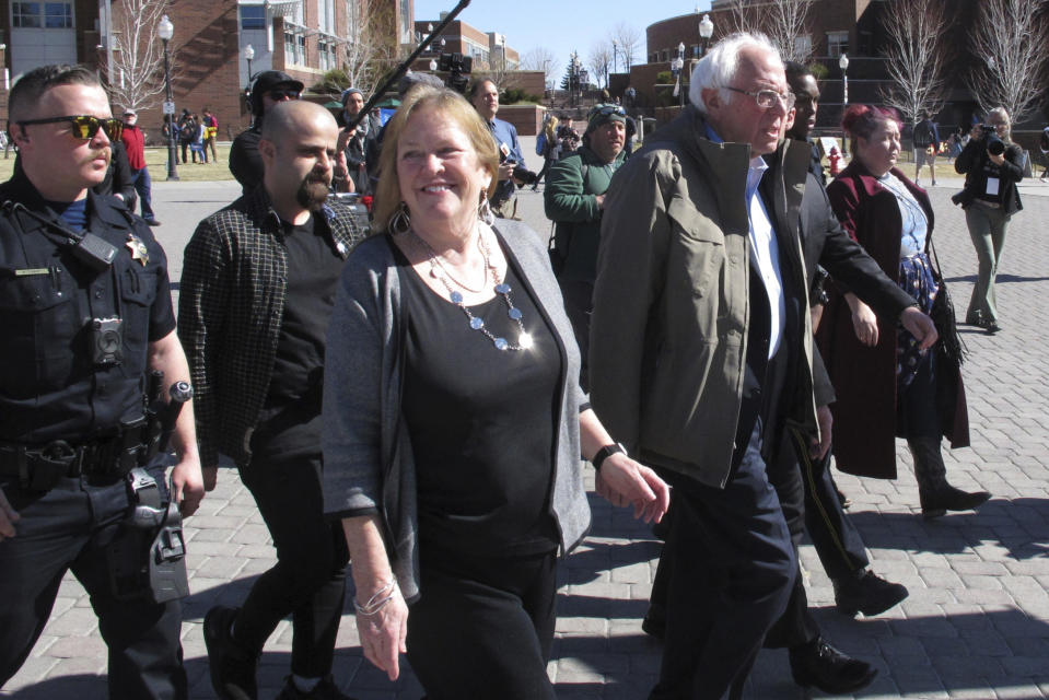 Democratic presidential candidate U.S. Sen. Bernie Sanders, I-Vt., right, and his wife Jane O'Meara Sanders, center, capped a speech to hundreds of people on the campus of the University on Nevada, Reno, Tuesday, Feb. 18, 2020, by leading several dozen on a two-block march to the student union to cast their ballot on the final day of early voting ahead of Saturday's presidential caucuses, Sanders accused billionaire rival Mike Bloomberg for trying to buy the Democratic nomination and said his own campaign is the campaign for working class people. (AP Photo/Scott Sonner)