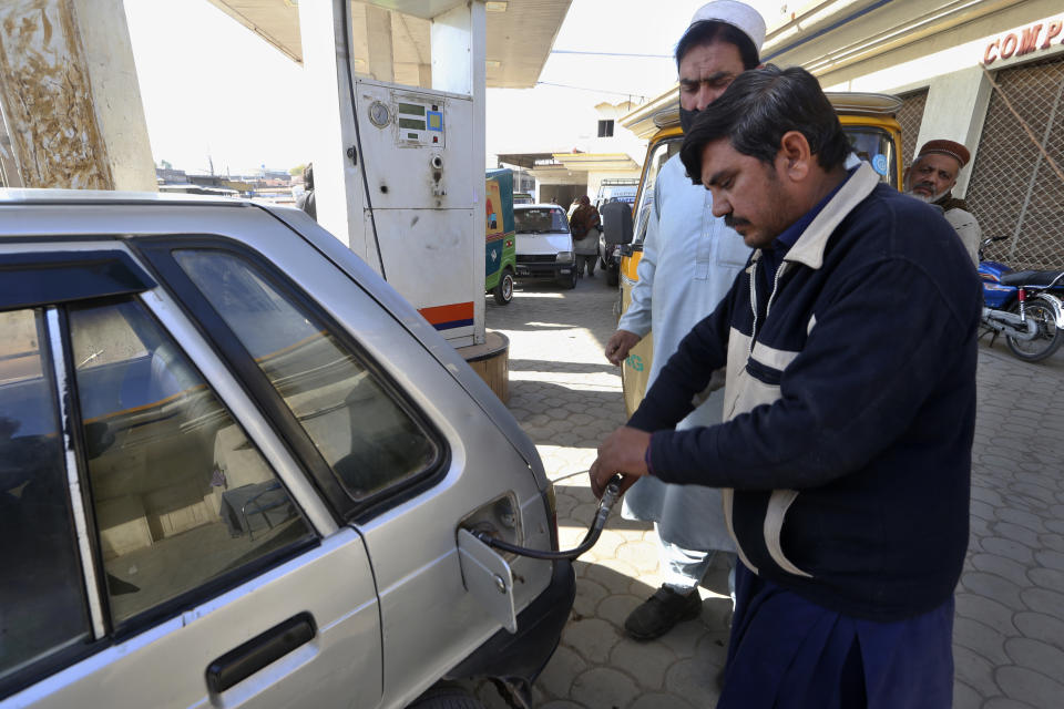 A worker fills gas into a car at a CNG station, in Peshawar, Pakistan, Tuesday, Feb. 14, 2023. Cash-strapped Pakistan nearly doubled natural gas taxes Tuesday in an effort to comply with a long-stalled financial bailout, raising concerns about the hardship that could be passed on to consumers in the impoverished south Asian country. Pakistan's move came as the country struggles with instability stemming from an economic crisis. (AP Photo/Muhammad Sajjad)