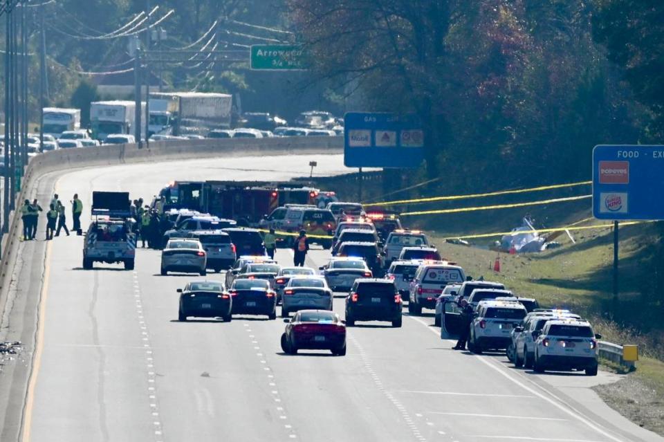 The remains of a helicopter sit to the right side of I-77 south past the Tyvola Road exit on Tuesday, November 22, 2022. Two people were confirmed dead in the crash, which involved a WBTV helicopter.