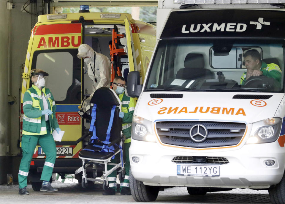 An ambulance crew works at a specialized COVID-19 hospital in Warsaw, Poland, Tuesday, Oct. 20, 2020. Poland is seeing a sharp spike in new cases daily of coronavirus infections, filling up hospital beds. Poland's government is transforming the National Stadium in Warsaw into a field hospital to handle the surging number of people infected with the coronavirus, and expects it to be operational within days, officials said. (AP Photo/Czarek Sokolowski)