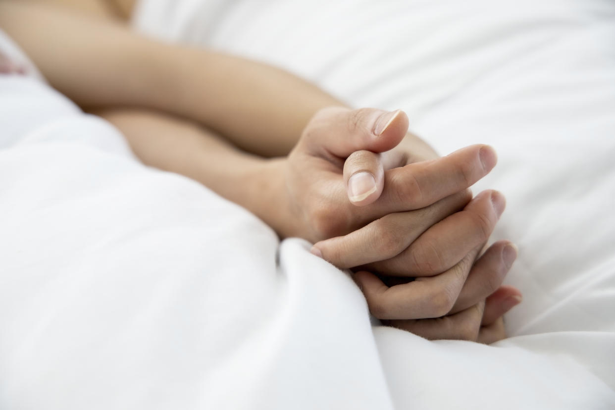 Love emotion concept:  hand of couple love on the white bed