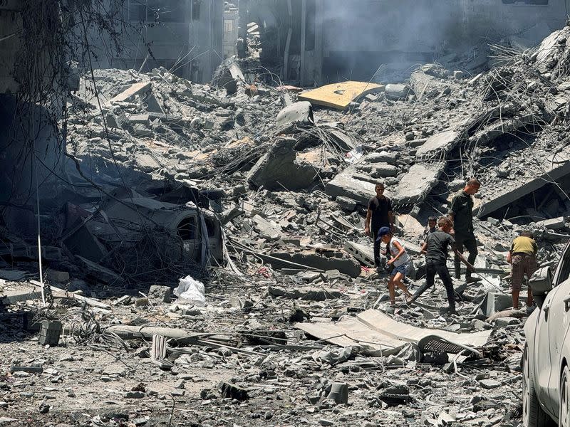 Palestinians search for casualties at the site of Israeli strikes on houses