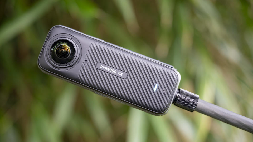 Insta360 X4 360 degree camera outdoors with vibrant grassy background