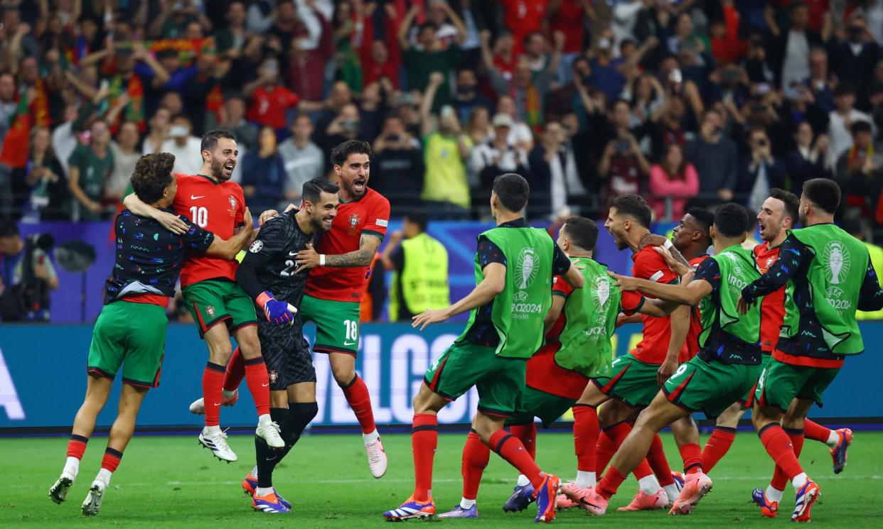 <span>Diogo Costa is mobbed his teammates after securing Portugal’s place in the quarter-finals.</span><span>Photograph: Kai Pfaffenbach/Reuters</span>