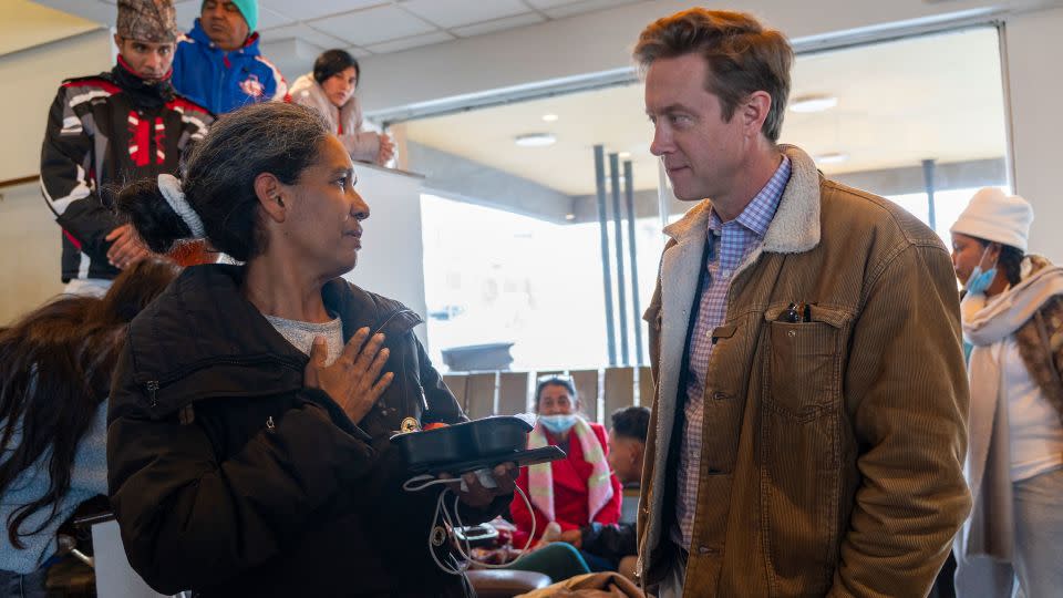 Yorgelis Fabiola, left, apologized to Denver Mayor Mike Johnston, right, for having to enter the US illegally.  - Evelio Contreras/CNN