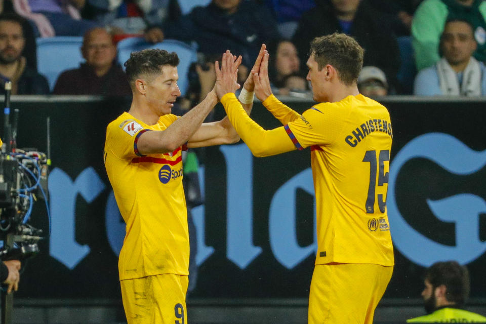 Barcelona's Robert Lewandowski, left, is congratulated after scoring his side's opening goal during the Spanish La Liga soccer match between Celta Vigo and Barcelona at the Balaidos stadium in Vigo, Spain, Saturday, Feb. 17, 2024. (AP Photo/Lalo R. Villar)