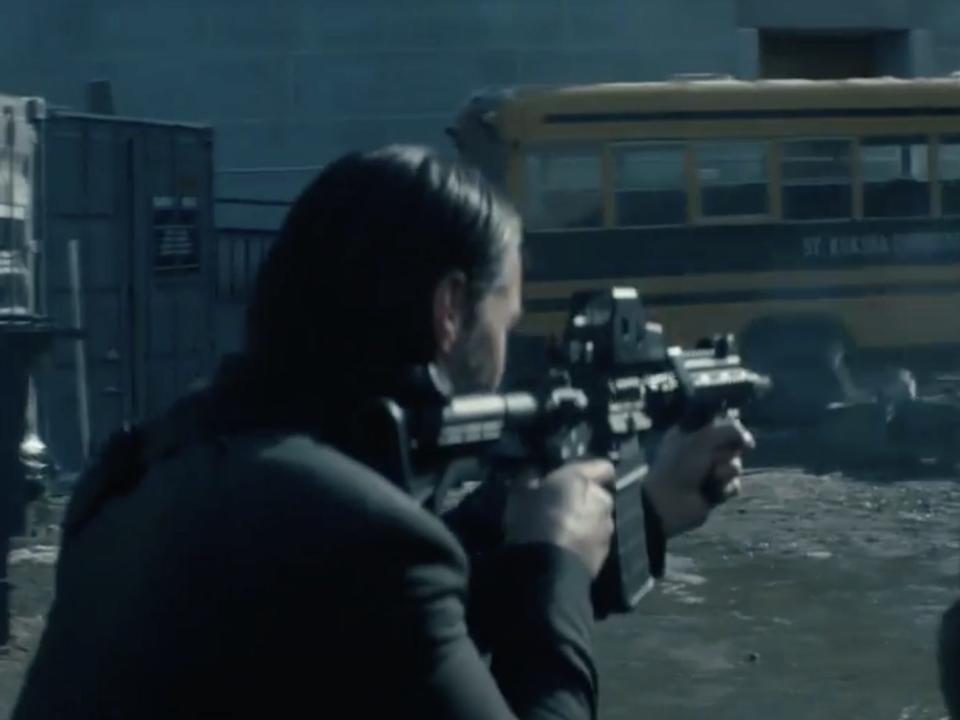 Keanu Reeves as John Wick shooting a rifle.