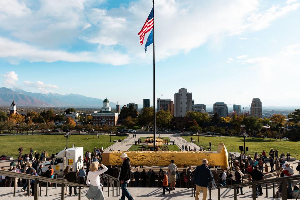 Attendees step up to see the Golden Spike Monument after its arrival in front of the Utah state Capitol in Salt Lake City on Monday, Oct. 23, 2023. The 43-foot-tall golden spike was commissioned as a public art piece by the Golden Spike Foundation to honor the tens of thousands of railroad workers who built the transcontinental railroad. | Megan Nielsen, Deseret News