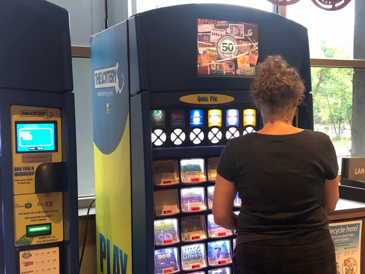 A woman in Boston buys a lottery ticket from a machine.
