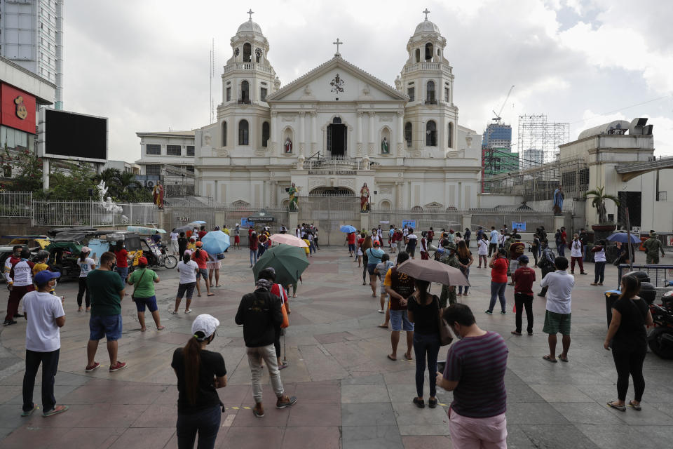 Devotees wait for their turn to go inside the Minor Basilica of the Black Nazarene, popularly known as Quiapo church as social distancing measure are placed to prevent the spread of the new coronavirus as it slowly reopens its doors in downtown Manila, Philippines on Friday, June 5, 2020. President Rodrigo Duterte has expressed relief that "Filipinos are really law-abiding" and that the Philippines was not going through riots like America which would make coronavirus quarantine enforcement formidable. (AP Photo/Aaron Favila)