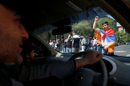 A man drives a car as opposition supporters protest against the ruling elite during a rally in Yerevan, Armenia April 26, 2018. REUTERS/Gleb Garanich