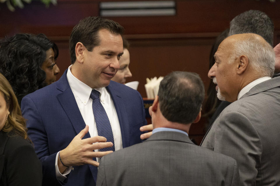 FILE - Nevada Secretary of State Cisco Aguilar talks with Lt. Gov. Stavros Anthony during the opening of the 82nd Session of the Nevada Legislature from the Assembly Chambers in Carson City, Nev., Feb. 6, 2023. To fight a poll worker shortage that is especially pronounced in rural counties, Aguilar is taking a page from counterparts elsewhere and proposing that the legal community be tapped to help address the problem. (AP Photo/Tom R. Smedes, File)