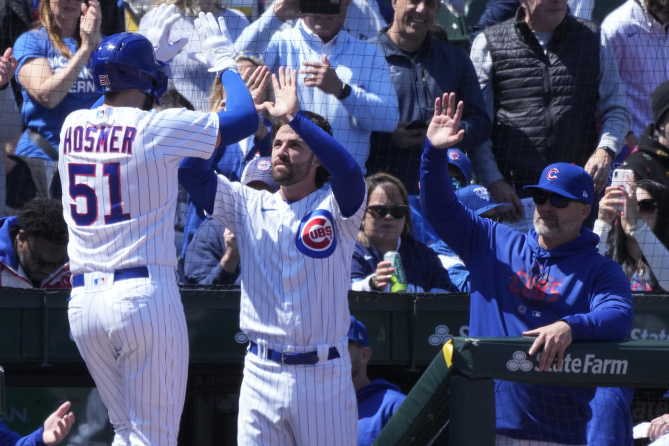 Chicago Cubs' Eric Hosmer, left, is congratulated by Dansby Swanson, center, and manager David Ross after hitting a solo home run during the second inning of a baseball game against the San Diego Padres in Chicago, Thursday, April 27, 2023. (AP Photo/Nam Y. Huh)