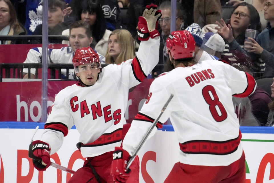 Carolina Hurricanes center Seth Jarvis (24) celebrates after his goal with teammate Brent Burns (8) during an NHL hockey game against the Toronto Maple Leafs in Toronto, Saturday, Dec. 30, 2023. (Frank Gunn/The Canadian Press via AP)