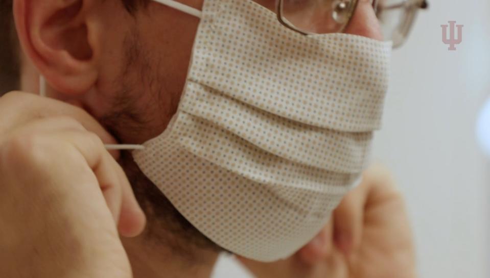 A researcher wearing a face mask made of electroceutical fabric.