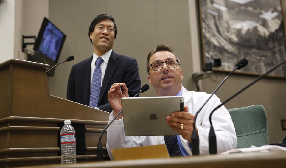 Bob Sears, a pediatrician from Orange County, right, testifies against a measure by state Sen. Dr. Richard Pan, D-Sacramento, left, who is also a pediatrician, that would give public health officials oversight of doctors that may be giving fraudulent medical expeditions from vaccinations during a hearing of the Assembly Health Committee at the Capitol in Sacramento, Calif., Thursday, June 20, 2019. (AP Photo/Rich Pedroncelli)