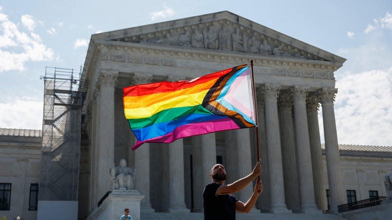 Same-sex marriage supporter Vin Testa, of Washington, DC, waves a LGBTQIA pride flag in front of the U.S. Supreme Court Building as he makes pictures with his friend Donte Gonzalez to celebrate the anniversary of the United States v. Windsor and the Obergefell v. Hodges decisions on June 26, 2023 in Washington, DC.