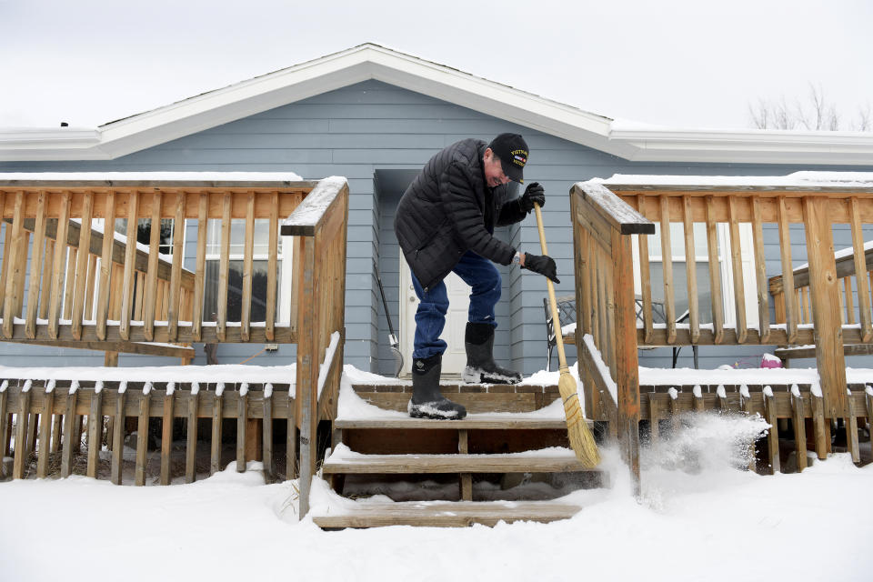 Richard King, 70, sweeps off the front steps to his home near Zortman, Mont., on the Fort Belknap Indian Reservation on Sunday, Dec. 8, 2019. King retired on disability in 2016 after serving as the director of the Fort Belknap Chemical Dependency Center. (AP Photo/Tommy Martino)