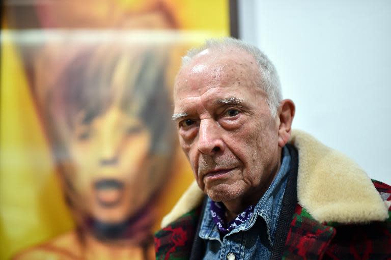 British photographer David Bailey poses in front of his pictures of Mick Jagger during the private preview of the exhibition "Stardust" on February 28, 2015 in Milan