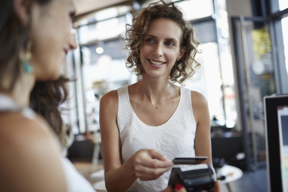 woman swiping her credit card