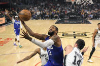 Los Angeles Clippers guard Paul George, center, shoots as San Antonio Spurs guard Dejounte Murray, lower left, and forward Drew Eubanks defend during the first half of an NBA basketball game Tuesday, Nov. 16, 2021, in Los Angeles. (AP Photo/Mark J. Terrill)