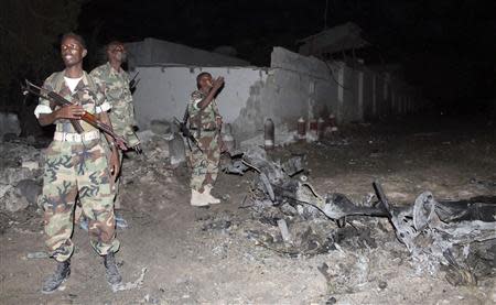 Soldiers assess the scene of an explosion outside the Jazira hotel in Mogadishu, January 1, 2014. REUTERS/Feisal Omar