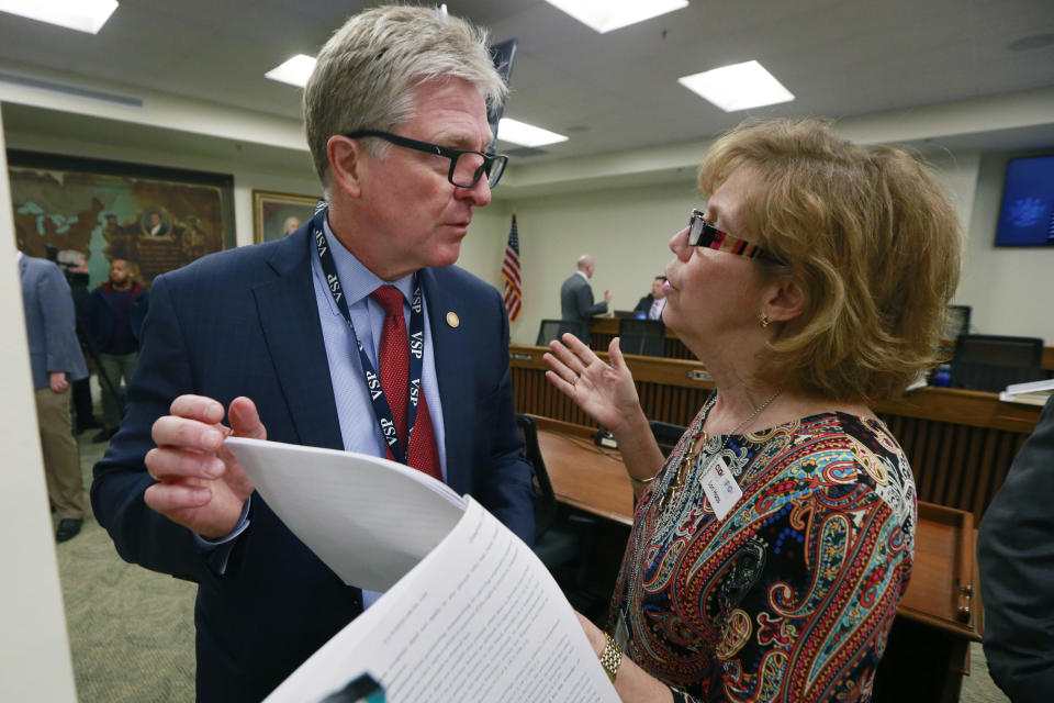 In this Jan. 13, 2020 photo, Virginia Secretary of Public Safety Brian Moran, left, talks with gun control advocate Lorie Haas, right, during a meeting of the Senate Judiciary committee at the Capitol in Richmond, Va. Haas is part of a small group of parents whose children were victims of the 2007 Virginia Tech massacre that have been the top gun-control lobbyists in the state for years, trying in vain for lawmakers to tighten gun laws. (AP Photo/Steve Helber)