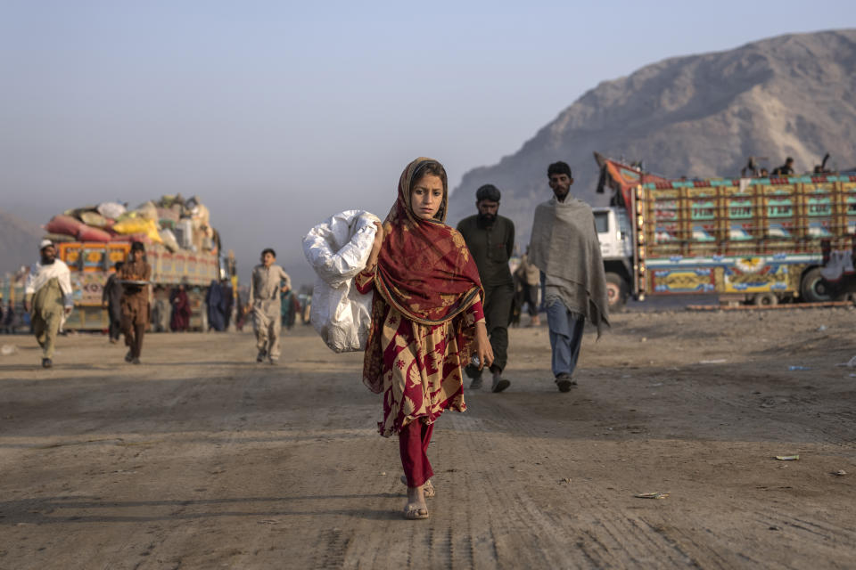 An Afghan refugee girl goes to collect garbage to burn for heating in a camp near the Torkham Pakistan-Afghanistan border in Torkham, Afghanistan, Saturday, Nov. 4, 2023. A huge number of Afghans refugees entered the Torkham border to return home hours before the expiration of a Pakistani government deadline for those who are in the country illegally to leave or face deportation. (AP Photo/Ebrahim Noroozi)