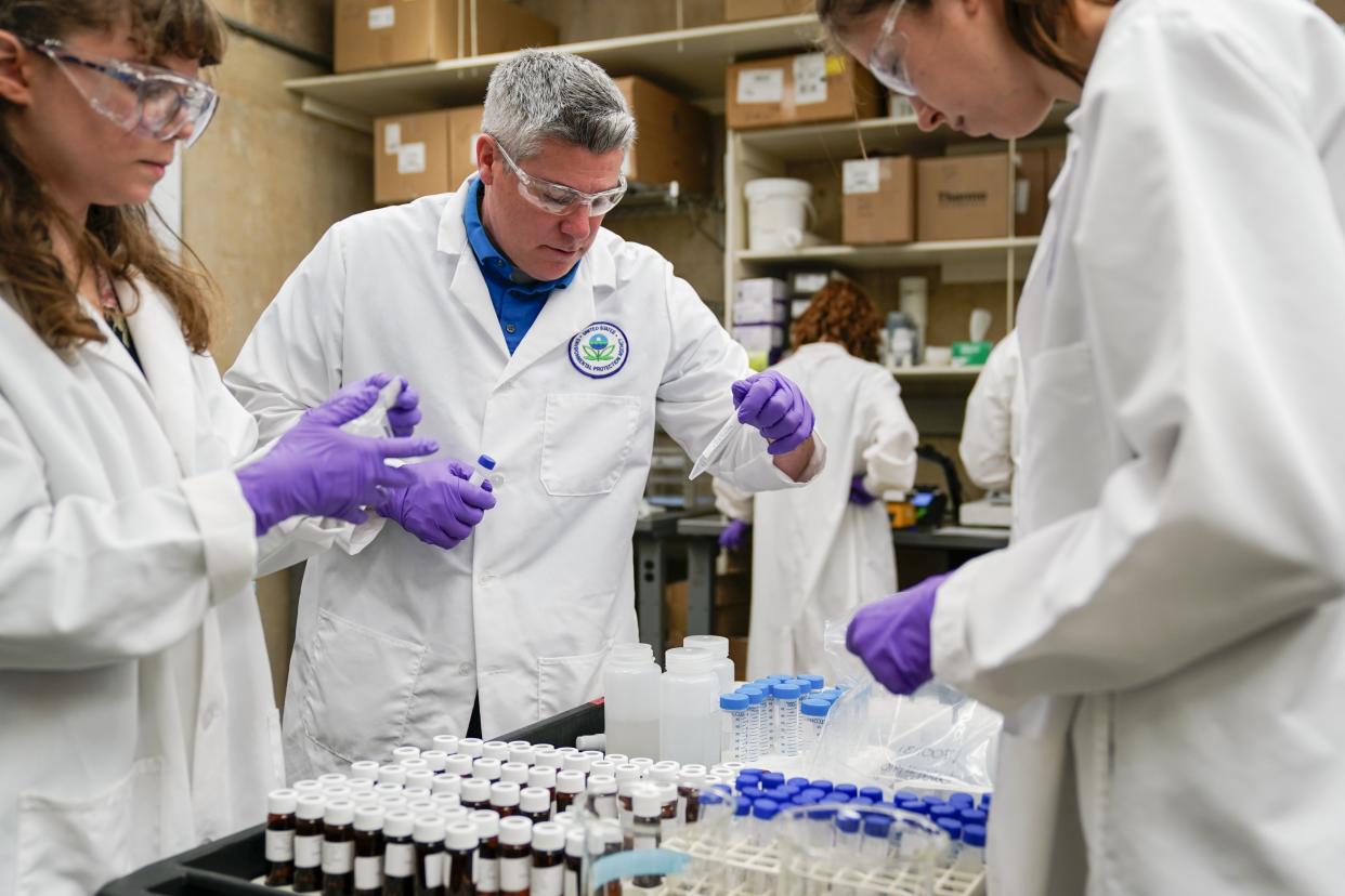 Eric Kleiner, center, sorts samples for experimentation as part of drinking water and PFAS research at the U.S. Environmental Protection Agency Center For Environmental Solutions and Emergency Response, Thursday, Feb. 16, 2023, in Cincinnati. The Environmental Protection Agency is expected to propose restrictions on harmful "forever chemicals" in drinking water after finding they are dangerous in amounts so small as to be undetectable, but experts say removing them will cost billions. (AP Photo/Joshua A. Bickel)