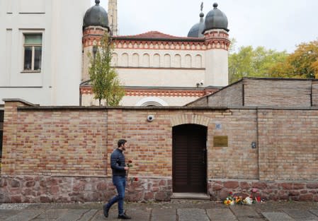 A man keeps flowers outside the synagogue in Halle