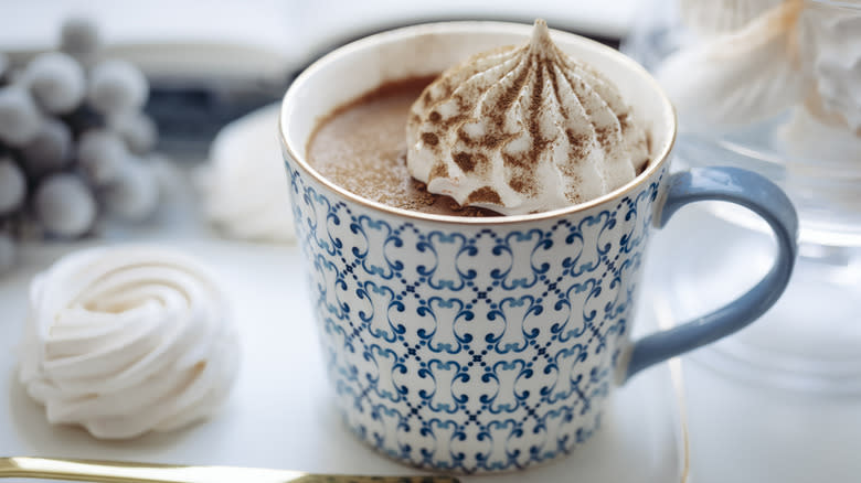 Blue and white mug of hot chocolate topped with cream