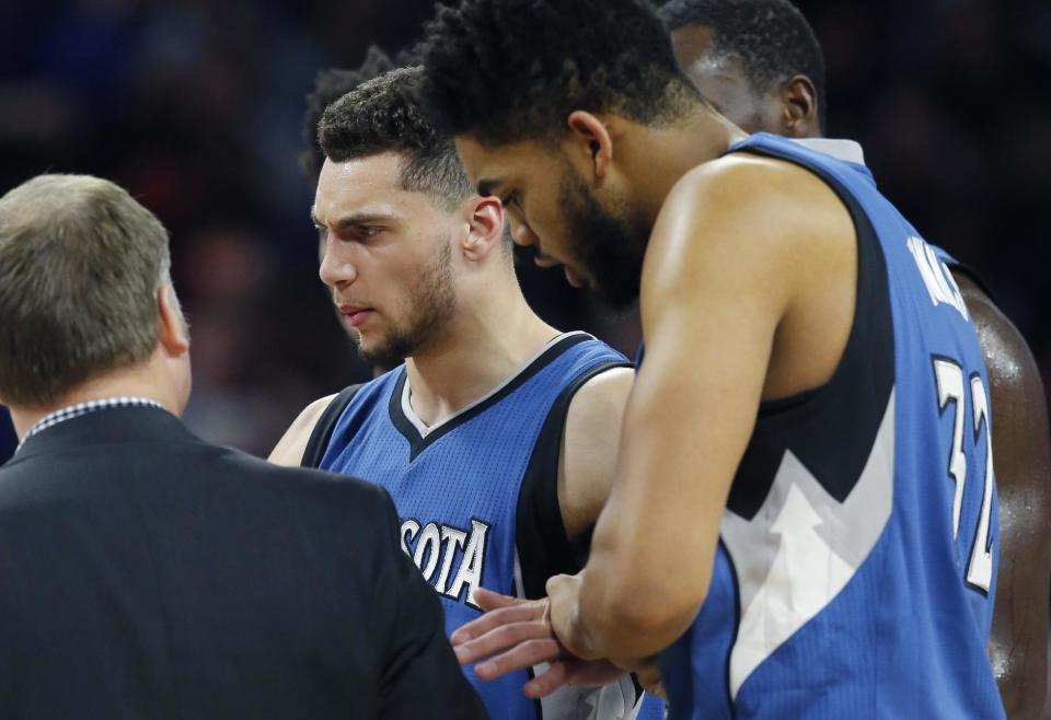 Minnesota Timberwolves guard Zach LaVine is helped off the court during the second half of the team's NBA basketball game against the Detroit Pistons, Friday, Feb. 3, 2017, in Auburn Hills, Mich. (AP Photo/Carlos Osorio)