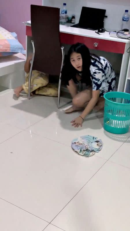 A still image from a social media video shows children hiding under a desk during an earthquake in Maumere, Indonesia