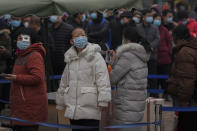 People wearing face masks to help protect from the coronavirus line up to get a swab for the COVID-19 test at a hospital in Beijing, Sunday, Jan. 23, 2022. Chinese authorities have called on the public to stay where they are during the Lunar New Year instead of traveling to their hometowns for the year's most important family holiday. (AP Photo/Andy Wong)