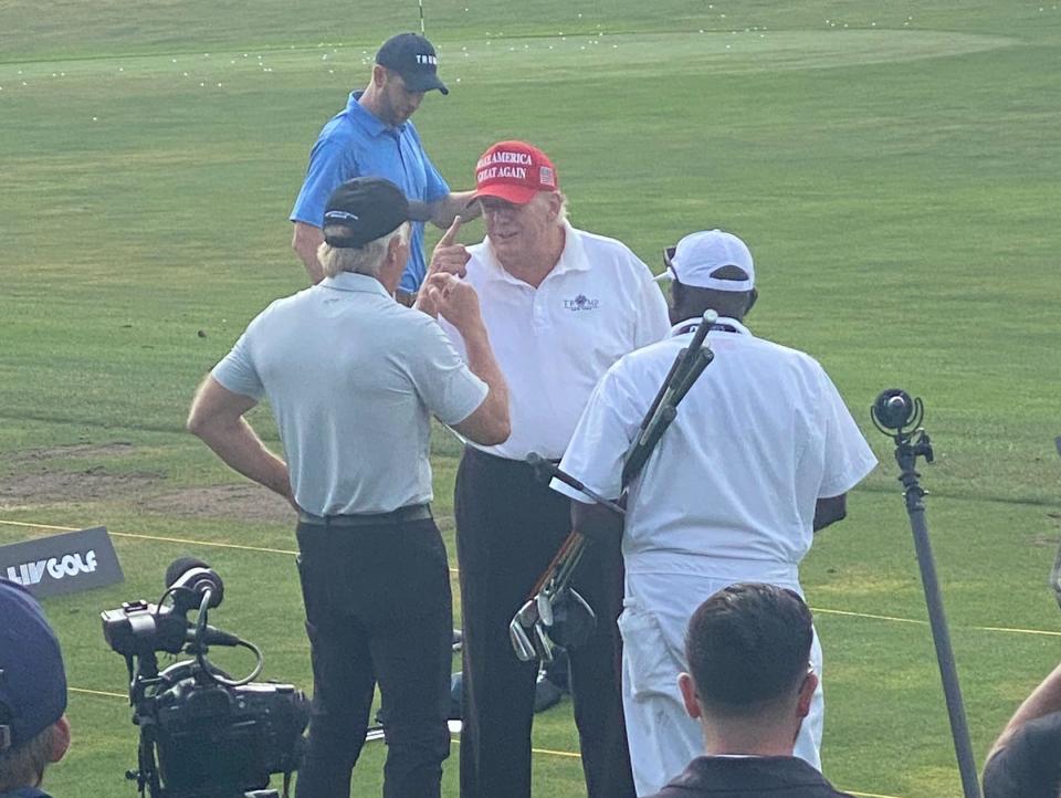 Trump speaks with LIV Golf CEO Greg Norman on the driving range.