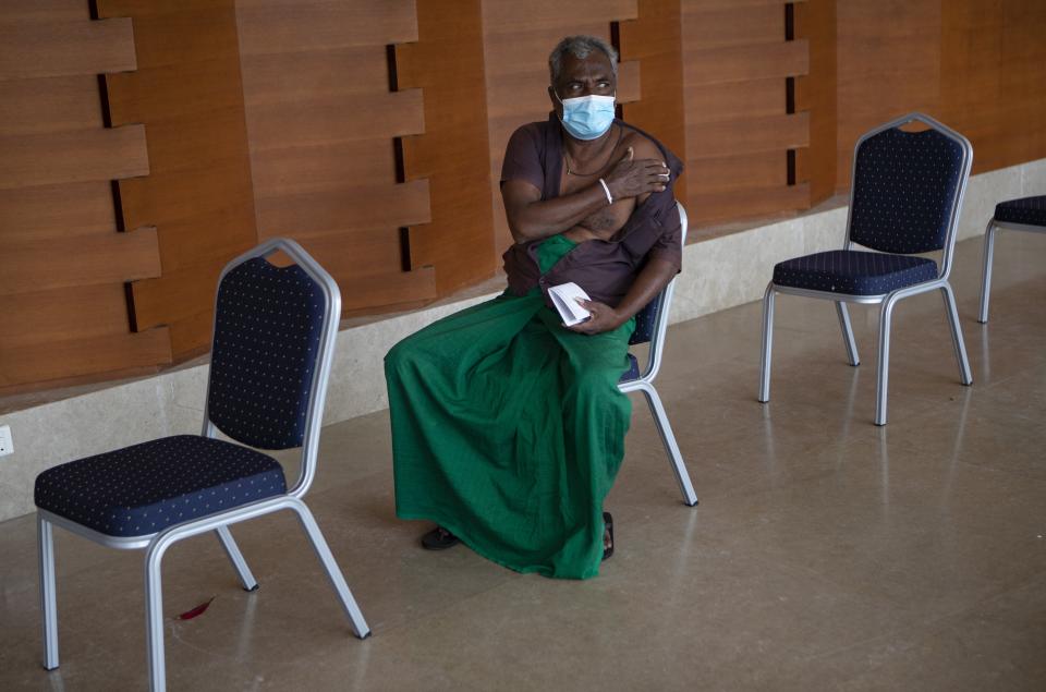 A Sri Lankan safari jeep driver holds his arm and rests after receiving his first jab of Sinopharm COVID-19 vaccine at a hotel in Weerawila, about 200 kilometers south east of Colombo, Sri Lanka, Saturday, July 10, 2021. (AP Photo/Eranga Jayawardena)