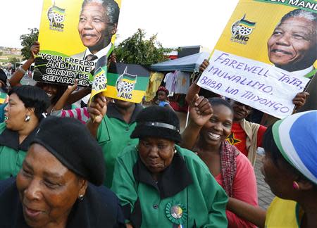 People sing and dance during a gathering of mourners on Vilakazi Street in Soweto, where the former South African President Nelson Mandela resided when he lived in the township, December 7, 2013. REUTERS/Yves Herman