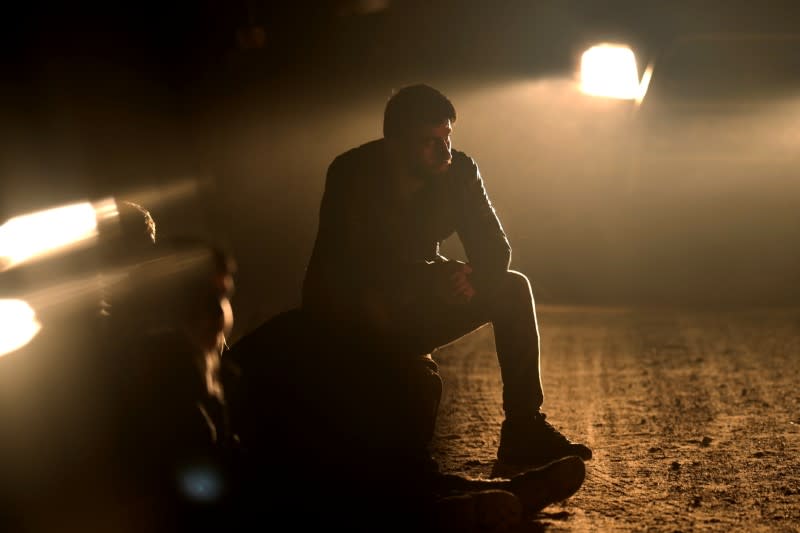 Detained migrant sits next to the Belarus-Latvia border near Vorzova